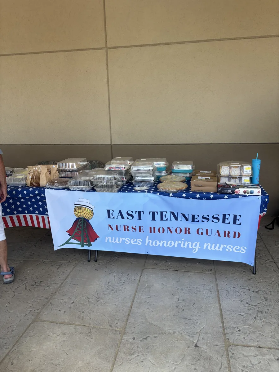 The East Tennessee Nurse Honor Guard banner on a stand beside a United States flag.