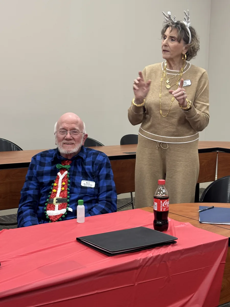 A chapter member in a festive holiday sweater and headband at the 2025 Christmas party.