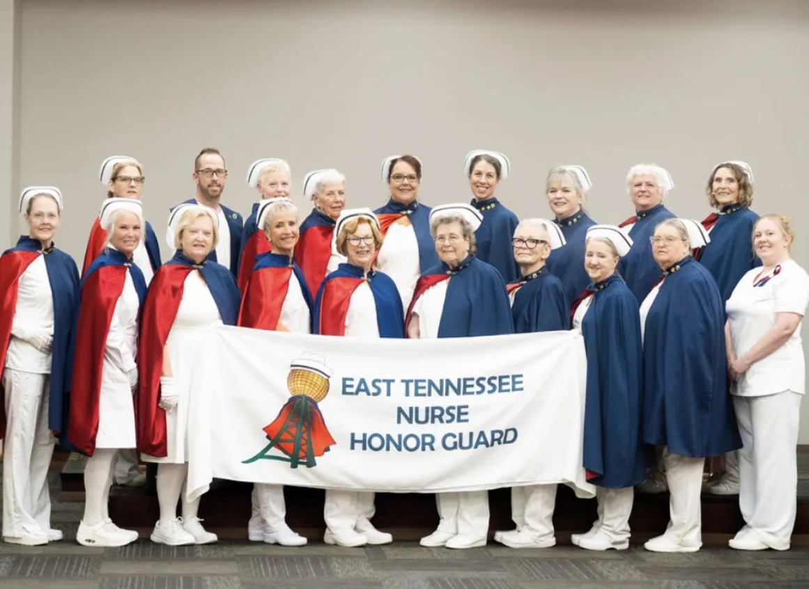 A large group of nurse honor guard members from several chapters gathered together on a covered porch.