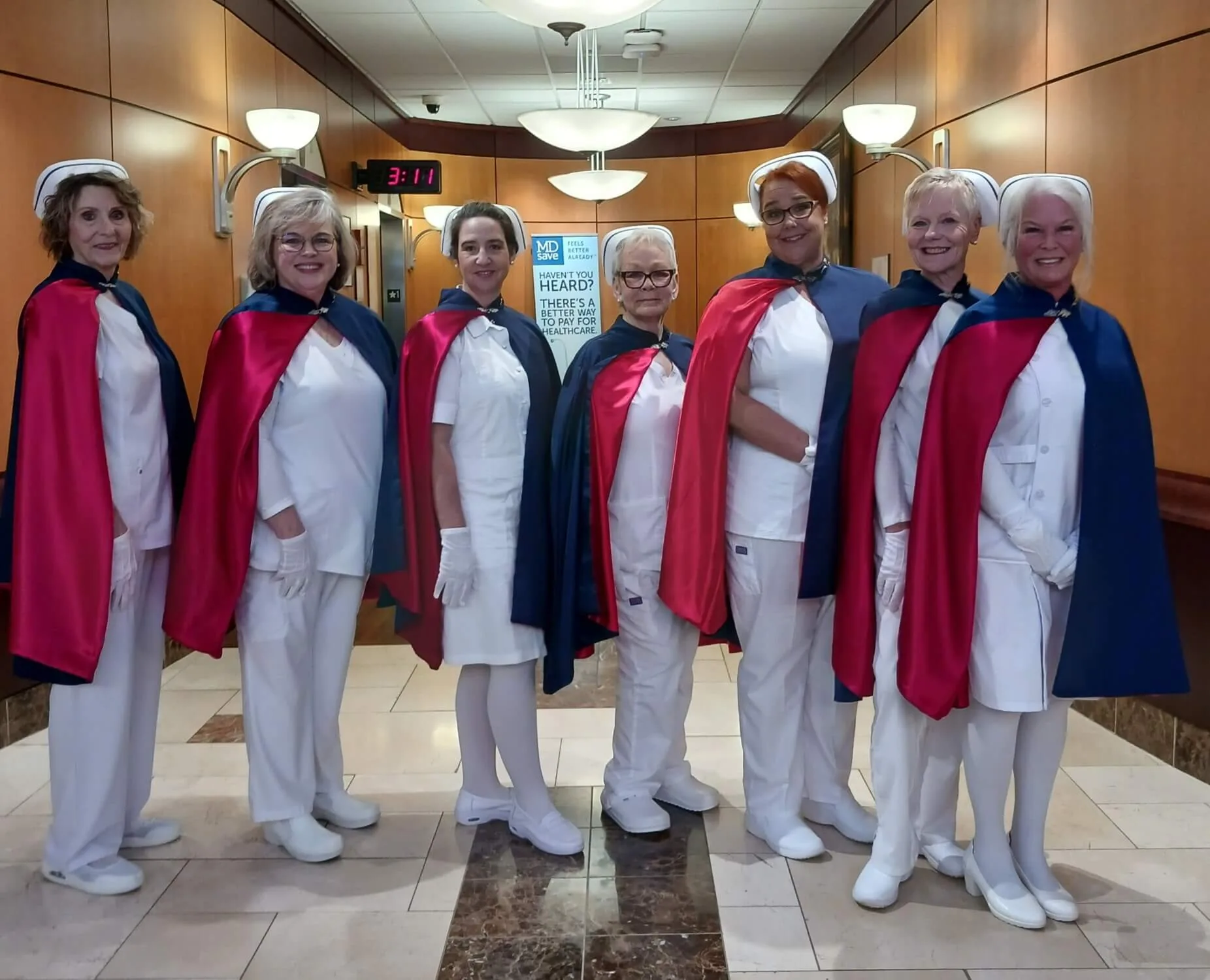 Seven honor guard members standing in formation in white uniforms and red and navy capes at the Living Tribute for Debra Foster, RN, on 27 February 2026.
