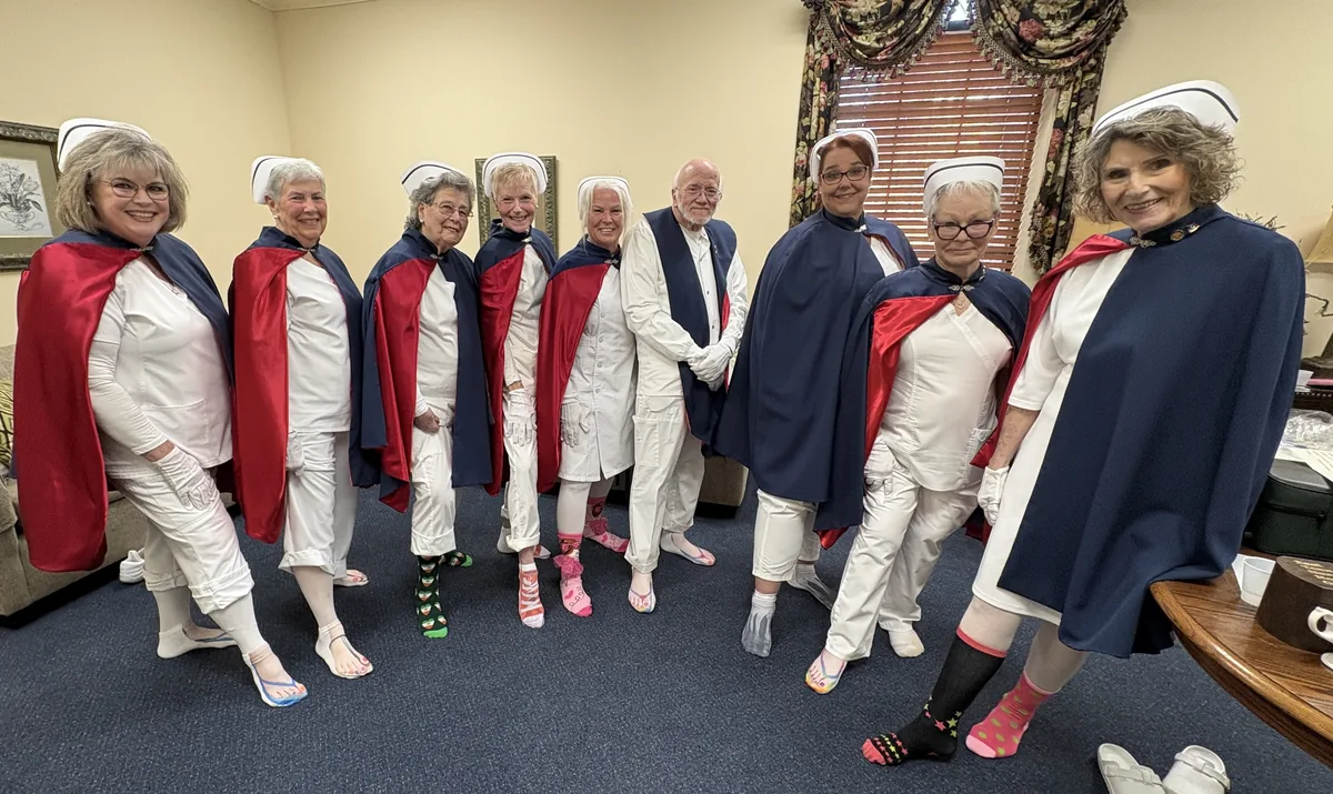 Honor guard members in uniform lifting the hems of their uniforms to show off matching holiday socks.