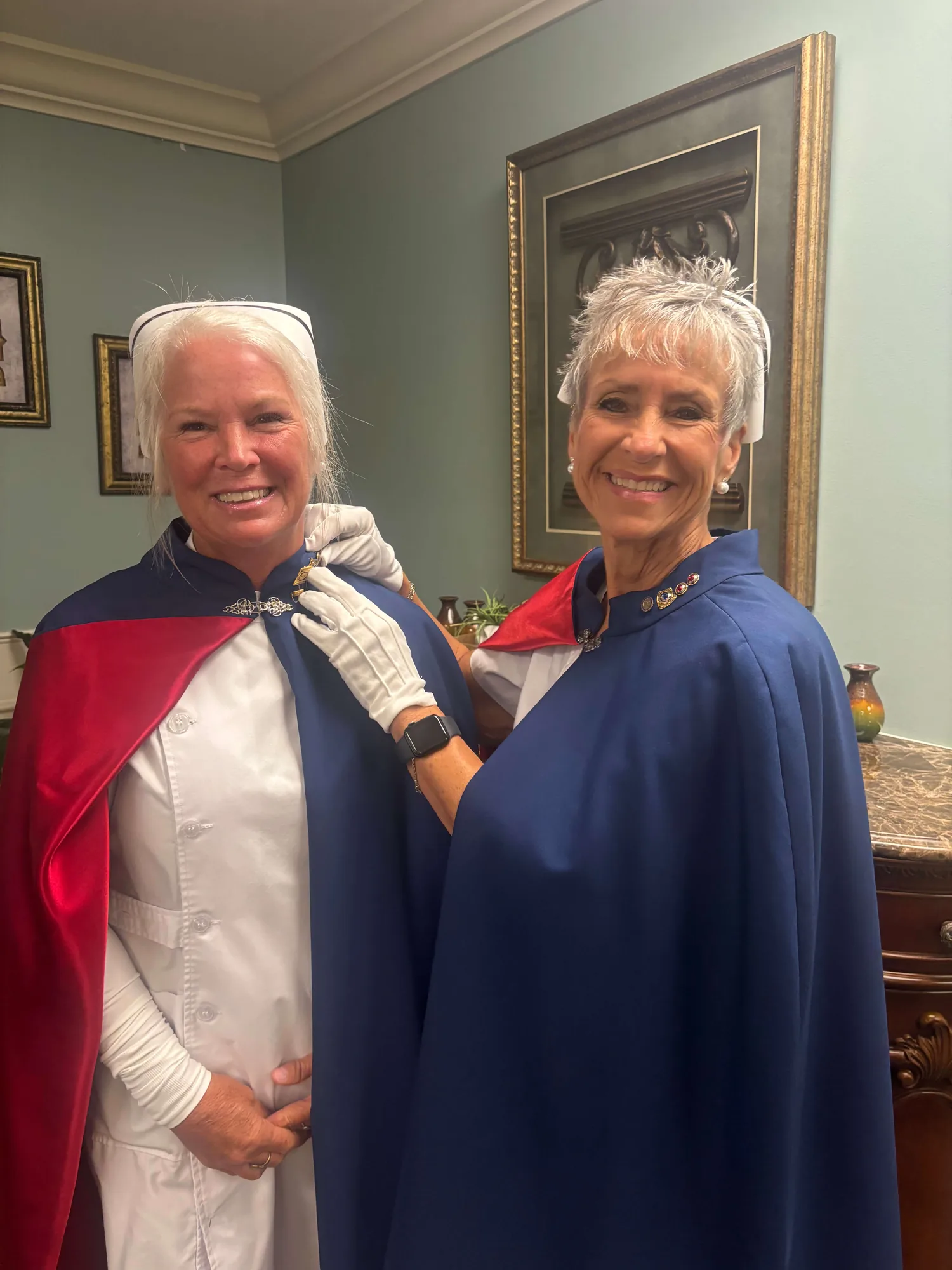 Cathy Felker, in white uniform and cape, being pinned by Melanie Pfennigwerth for twenty-five services with the East Tennessee Nurse Honor Guard.