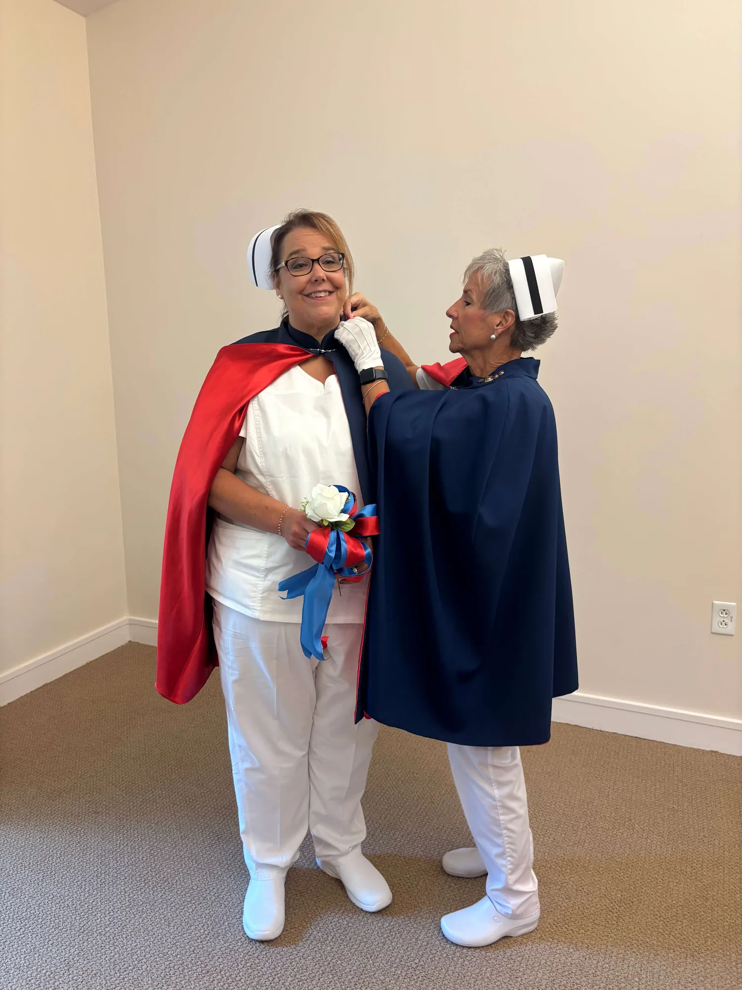 Christina Trentham, in white uniform and cape, being pinned by Melanie Pfennigwerth for twenty-five services with the East Tennessee Nurse Honor Guard.