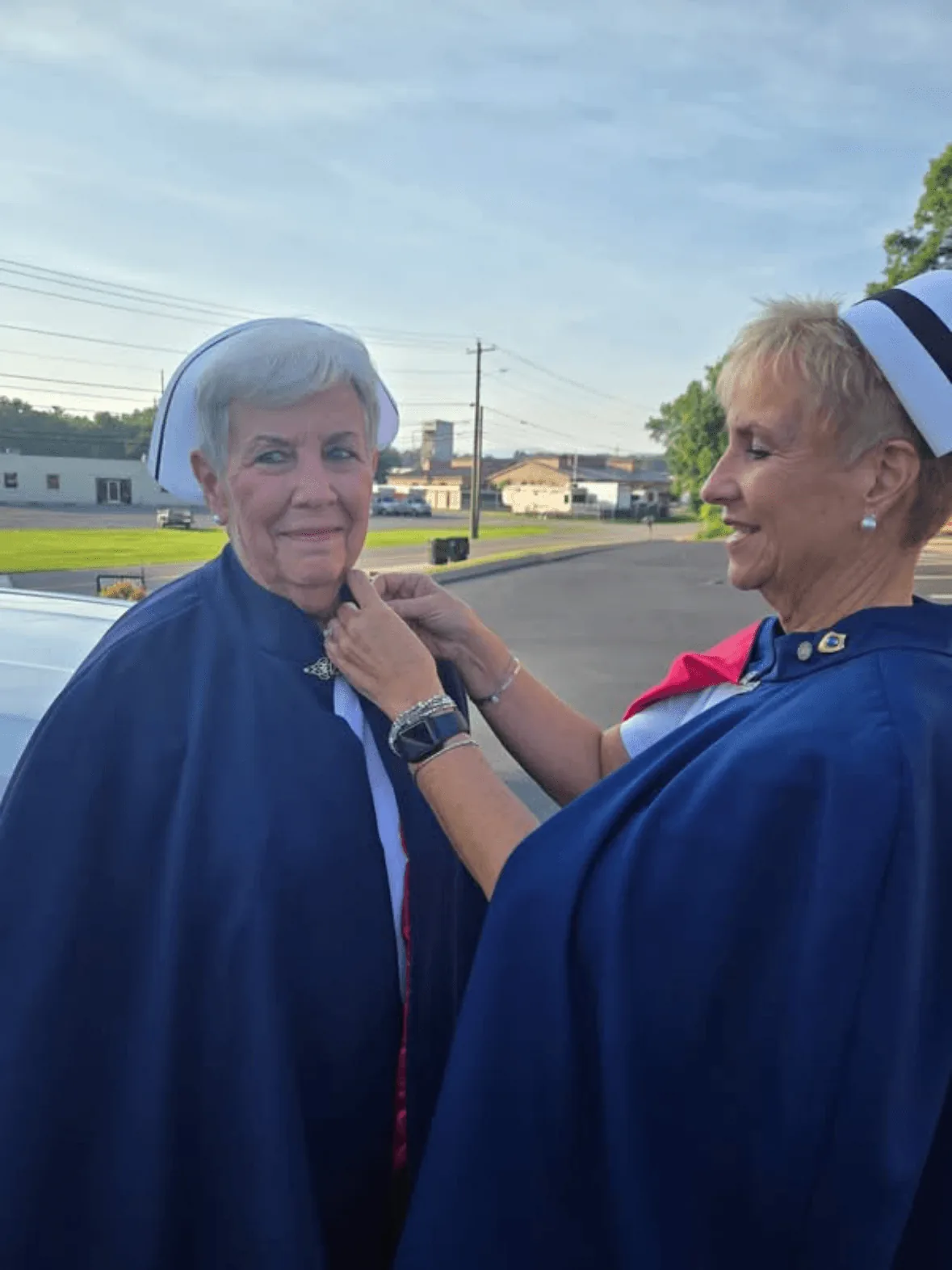 Ann Allen, in white uniform and cape, being pinned by Melanie Pfennigwerth to mark a first service with the East Tennessee Nurse Honor Guard.