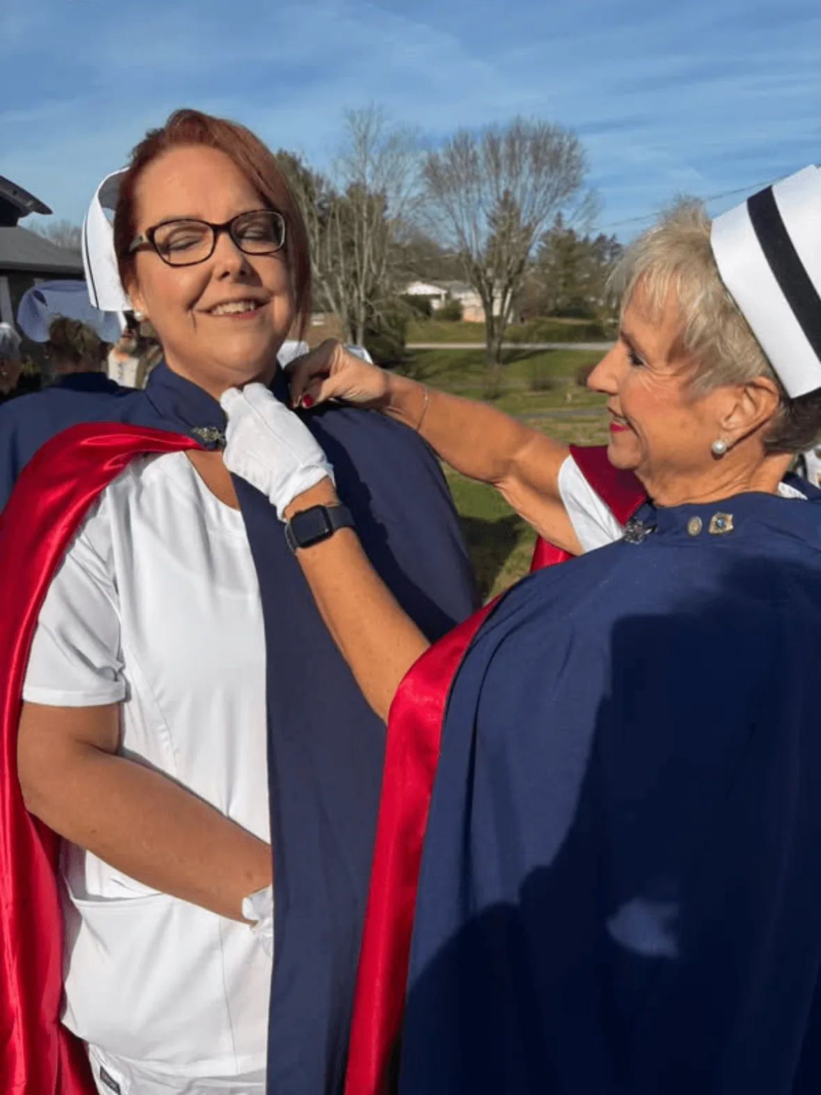 Christina Trentham, in white uniform and cape, being pinned by Melanie Pfennigwerth to mark a first service with the East Tennessee Nurse Honor Guard.