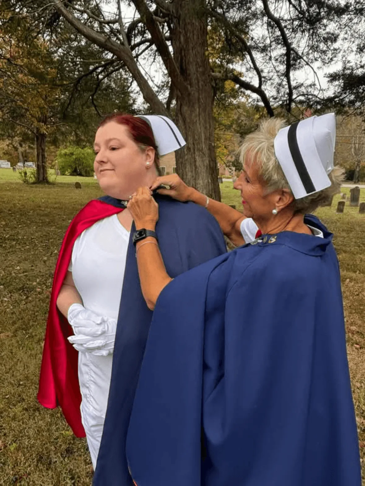 Christy Bullard, in white uniform and cape, being pinned by Melanie Pfennigwerth to mark a first service with the East Tennessee Nurse Honor Guard.