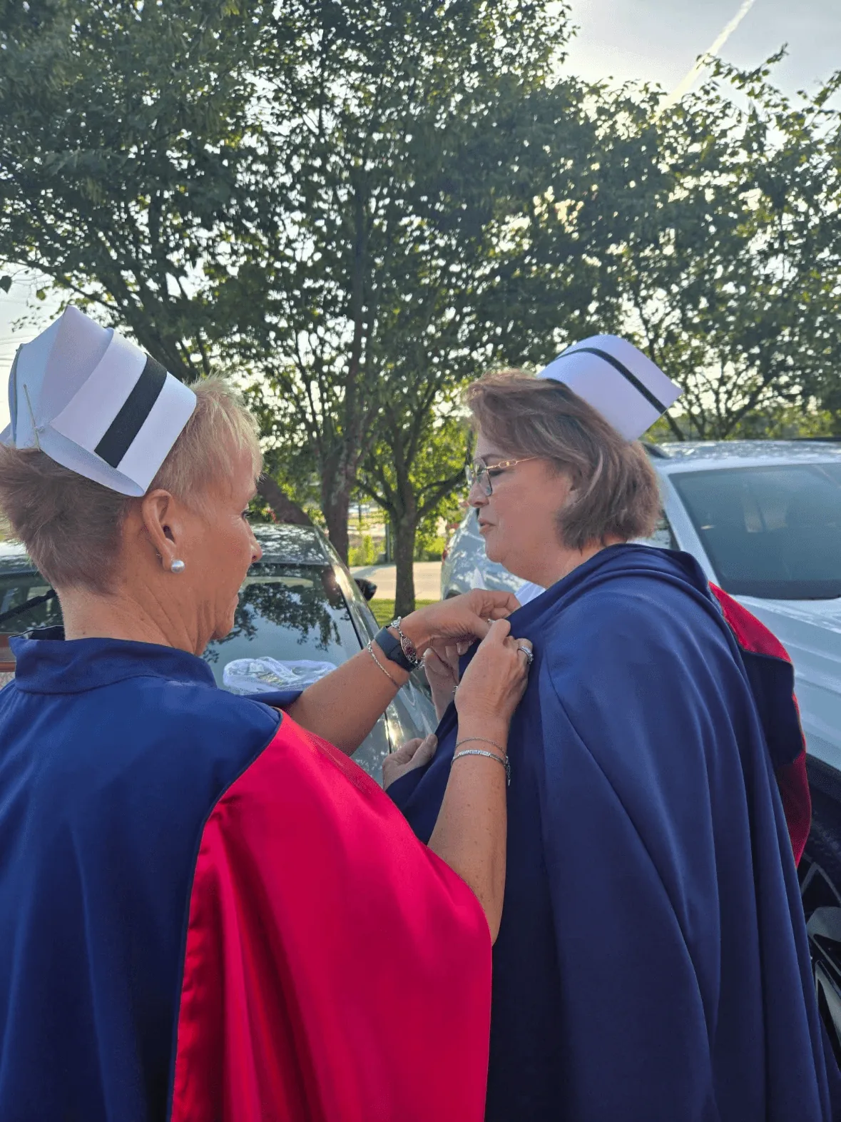 Dawn Evans, in white uniform and cape, being pinned by Melanie Pfennigwerth to mark a first service with the East Tennessee Nurse Honor Guard.