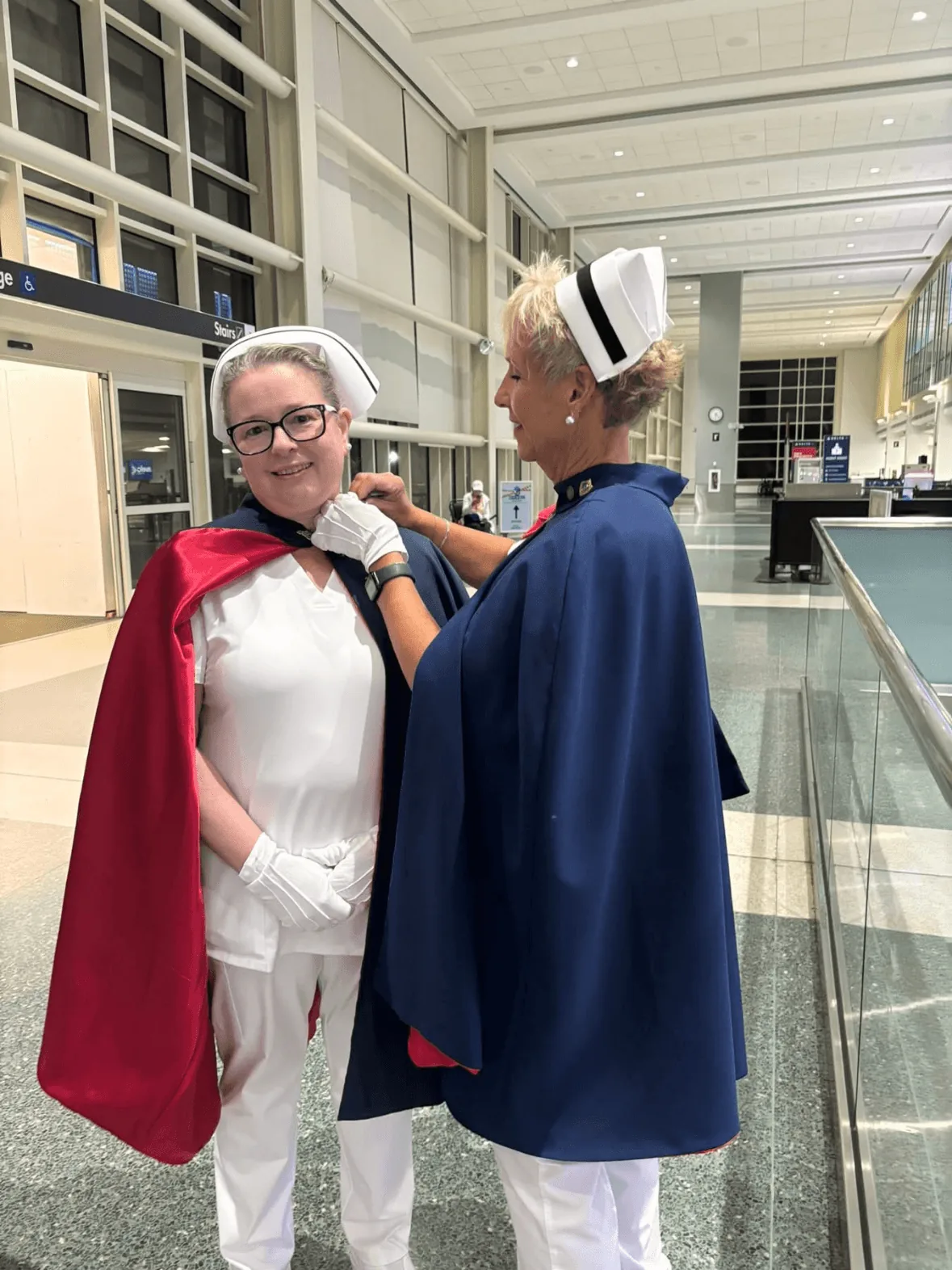 Ellen Lamkey, in white uniform and cape, being pinned by Melanie Pfennigwerth to mark a first service with the East Tennessee Nurse Honor Guard.