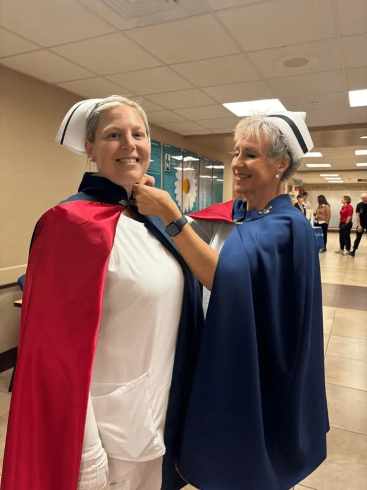 Kassandra Mether, in white uniform and cape, being pinned by Melanie Pfennigwerth to mark a first service with the East Tennessee Nurse Honor Guard.