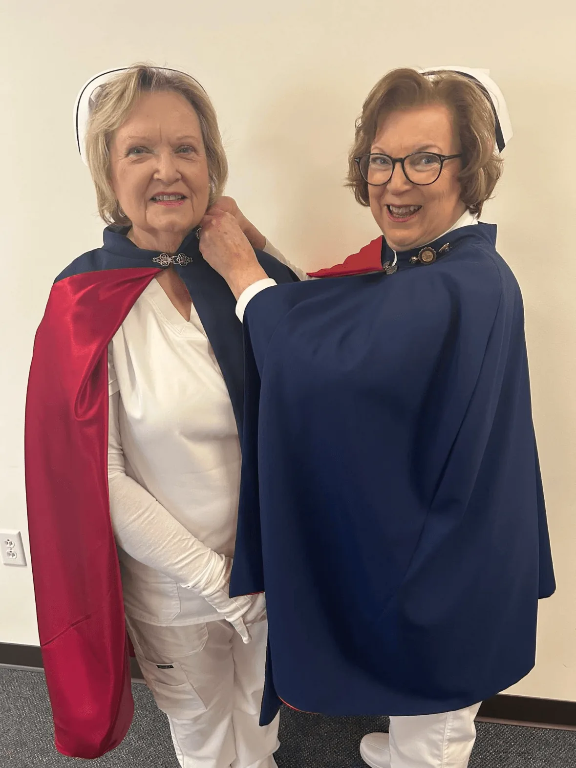Kathy Myers, in white uniform and cape, being pinned by Jan Phillips to mark a first service with the East Tennessee Nurse Honor Guard.