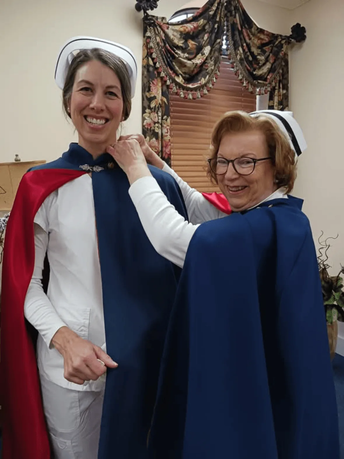 Lacey Wendland, in white uniform and cape, being pinned by Jan Phillips to mark a first service with the East Tennessee Nurse Honor Guard.