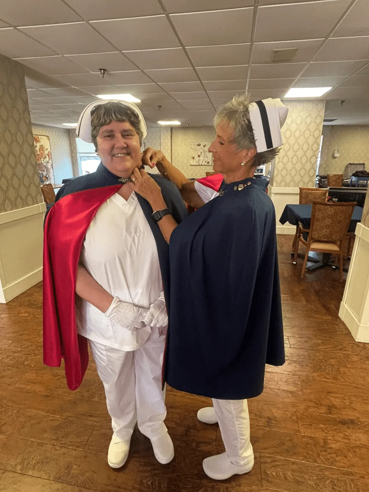 Rose Fuller, in white uniform and cape, being pinned by Melanie Pfennigwerth to mark a first service with the East Tennessee Nurse Honor Guard.
