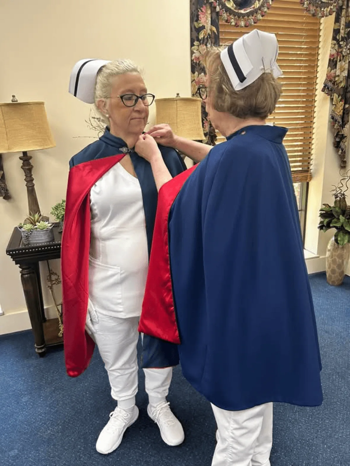 Susan Howell, in white uniform and cape, being pinned by Jan Phillips to mark a first service with the East Tennessee Nurse Honor Guard.