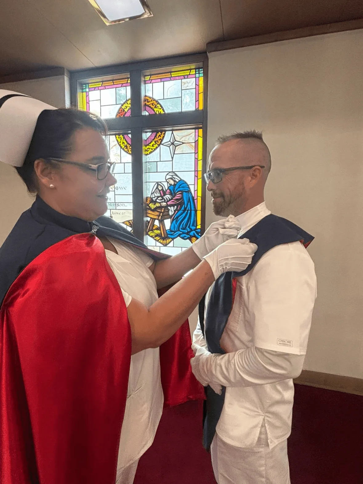 Tyler Ryan, in white uniform and cape, being pinned by Christina Trentham to mark a first service with the East Tennessee Nurse Honor Guard.