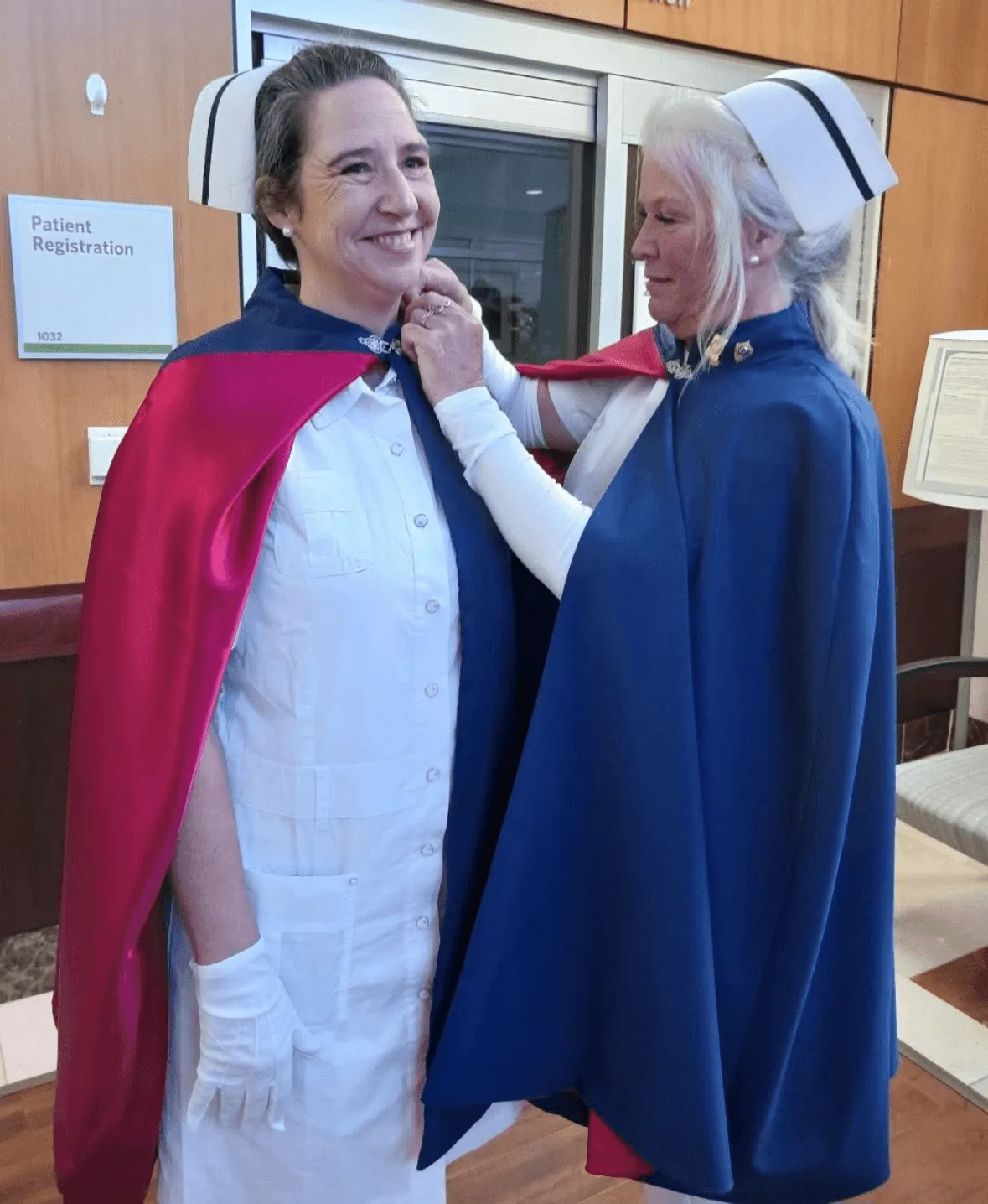 Wendy Wyatt, in white uniform and cape, being pinned by Cathy Felker to mark a first service with the East Tennessee Nurse Honor Guard.